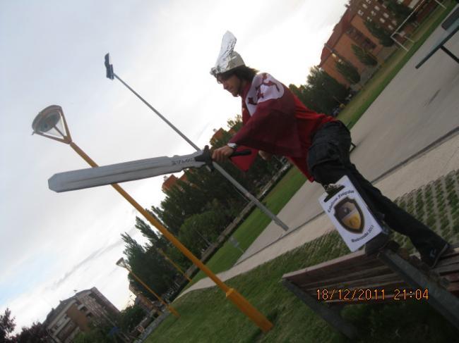 25.- Con un gorro de papel de plata, una espada en la mano y estando de pie encima de un banco de la calle [C.F.]