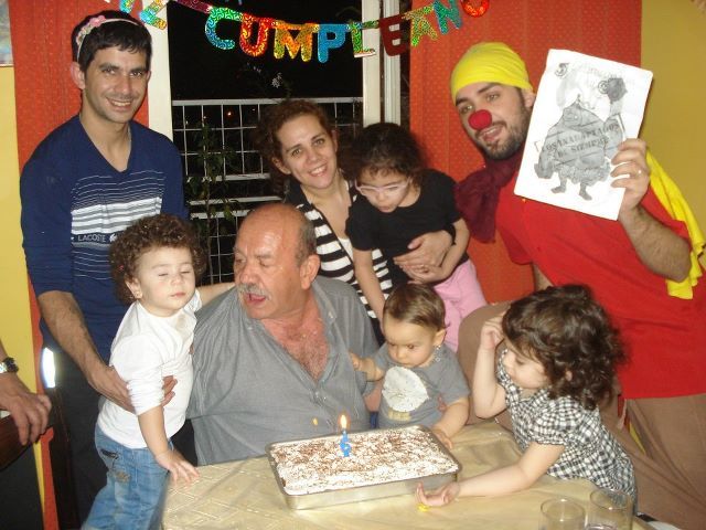 24. Disfrazado/a de payaso en el cumpleaños de un/a niño/a, junto a su tarta mientras éste/a apaga las velas.