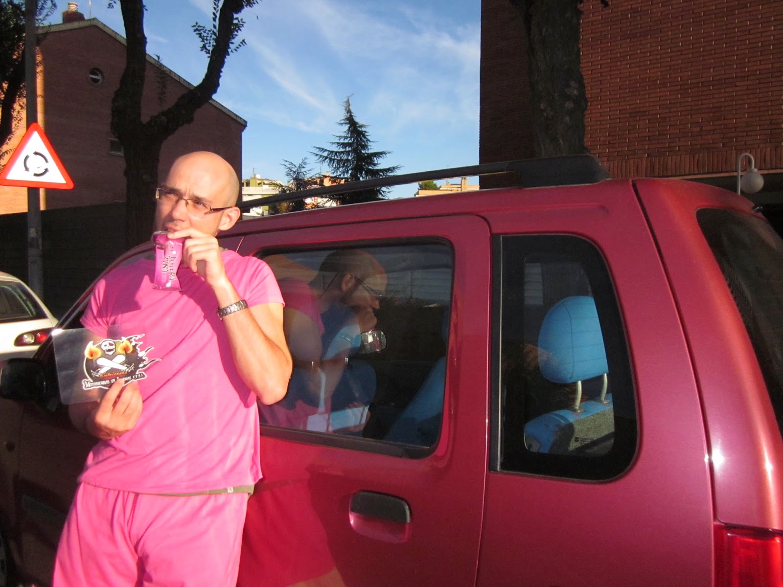 95. Vestido de color rosa, mientras te comes un bollito Pantera Rosa, junto a un coche rosa.