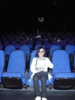 12. En un cine viendo una película desde la primera fila con gafas 3D.
