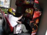 65. Dentro de una máquina recreativa de coches con un casco integral jugando una partida.