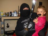 90. Vestido de ninja con un bebe entre los brazos.