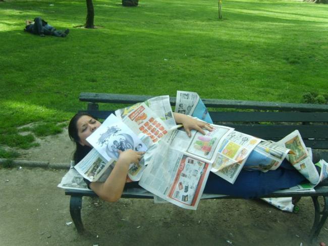 40. Tumbado en el banco de una plaza tapado con periódicos.