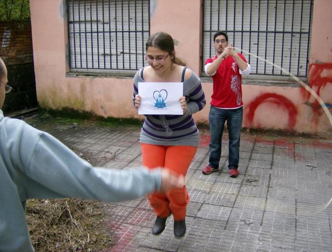 11. Saltando a la comba con el logo del grupo en la mano y sin tener ningún pie en el suelo.