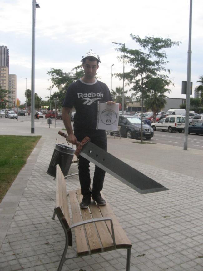 25. Con un gorro de papel de plata, una espada en la mano y estando de pie encima de un banco de la calle.