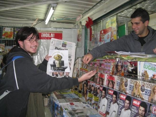 80 -En un puesto de diarios y revistas comprando el periodico (si se hace en un puesto de diarios y revistas de Constitución, Capital Federal, sito en