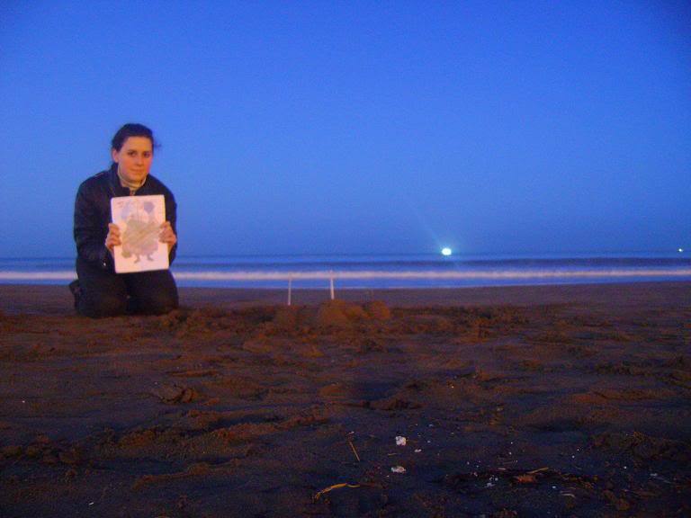 86: Con un castillo de arena en la playa, con el mar de fondo al atardecer o amanecer