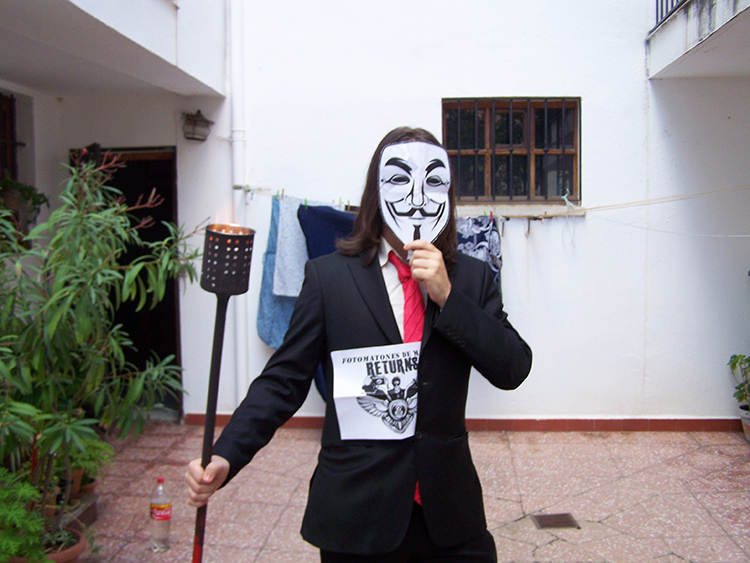 34. Un/a umbriano/a con la máscara de V de vendetta y una antorcha en la mano.