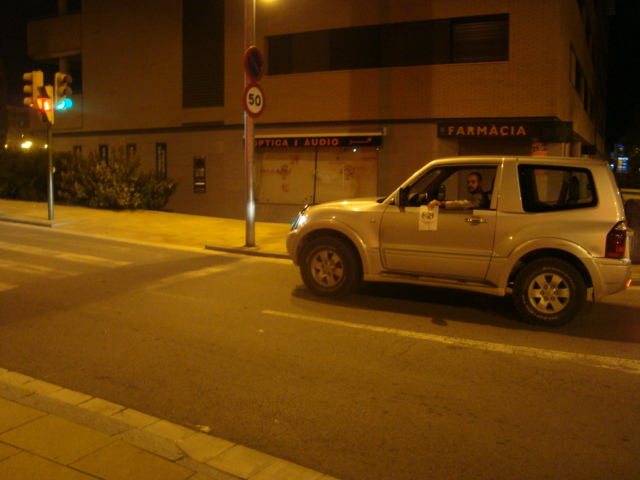 78.- Vestido/a elegantemente, en un coche de alta gama, parado/a en un semáforo.