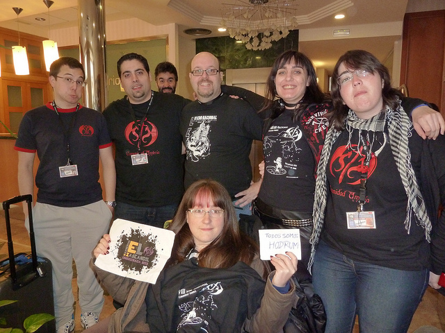  78.  En un grupo de al menos cinco umbrianos/as, con camisetas umbrianas, y un cartel que diga 