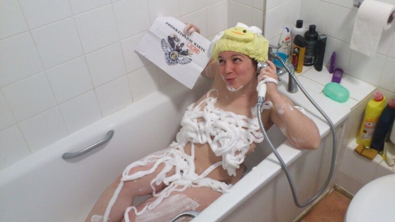 29. Cubierto/a de espuma, en la bañera, usando el mango de la ducha como si fuera un teléfono.