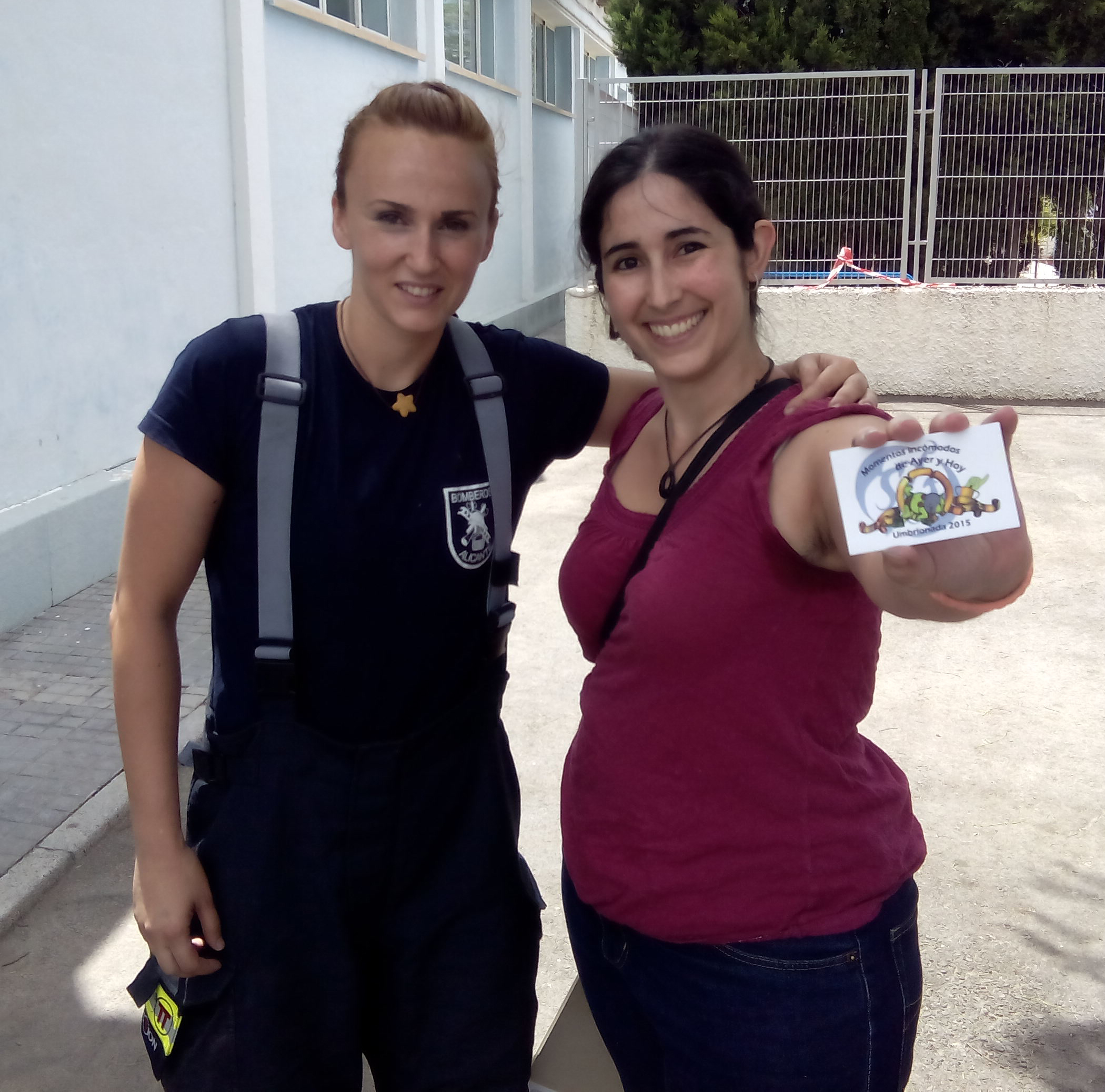 98. Junto a una mujer bombero uniformada.