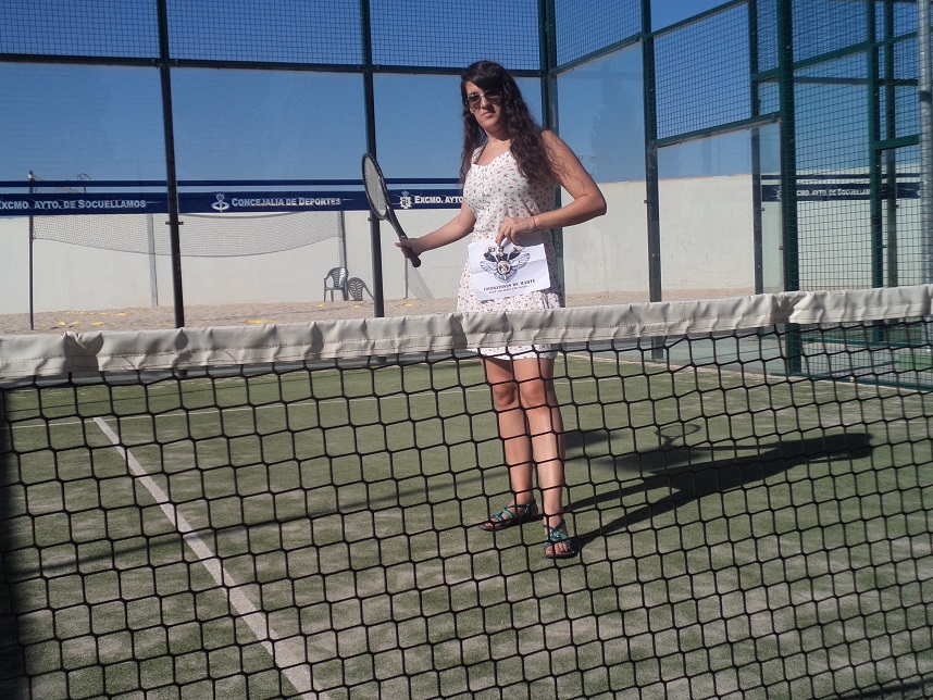 96. Con una raqueta de tenis en una cancha de paddle.