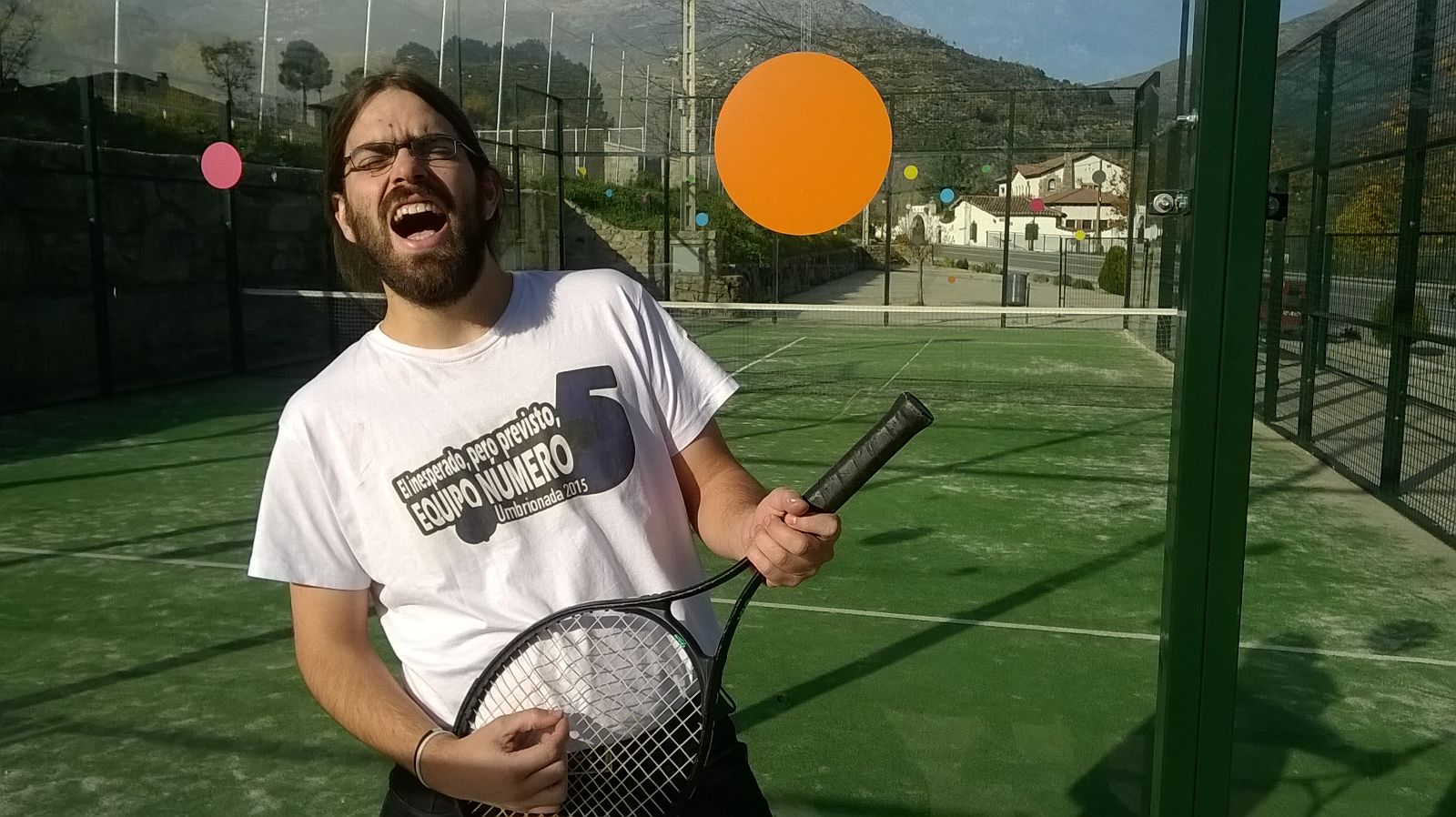 96. Con una raqueta de tenis en una cancha de paddle.