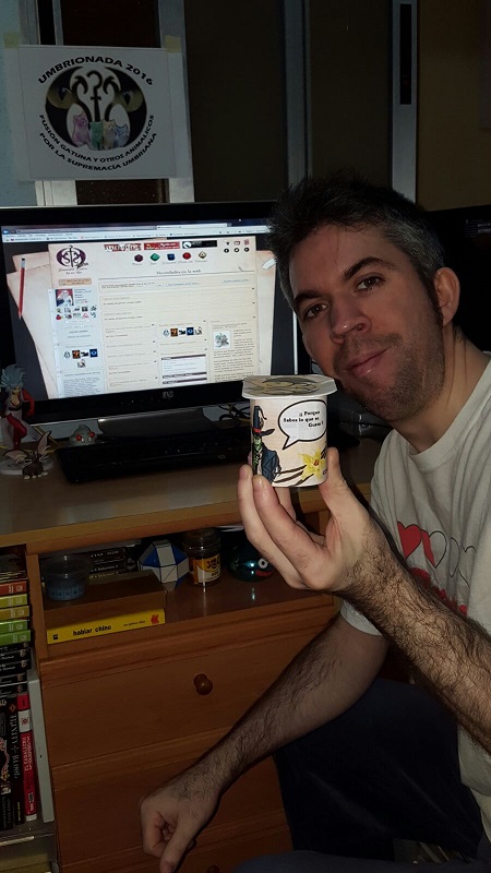 59. Con un yogur que muestre el logotipo de comunidad umbría (nada de dibujos cutres), mostrando la página inicial de la web.