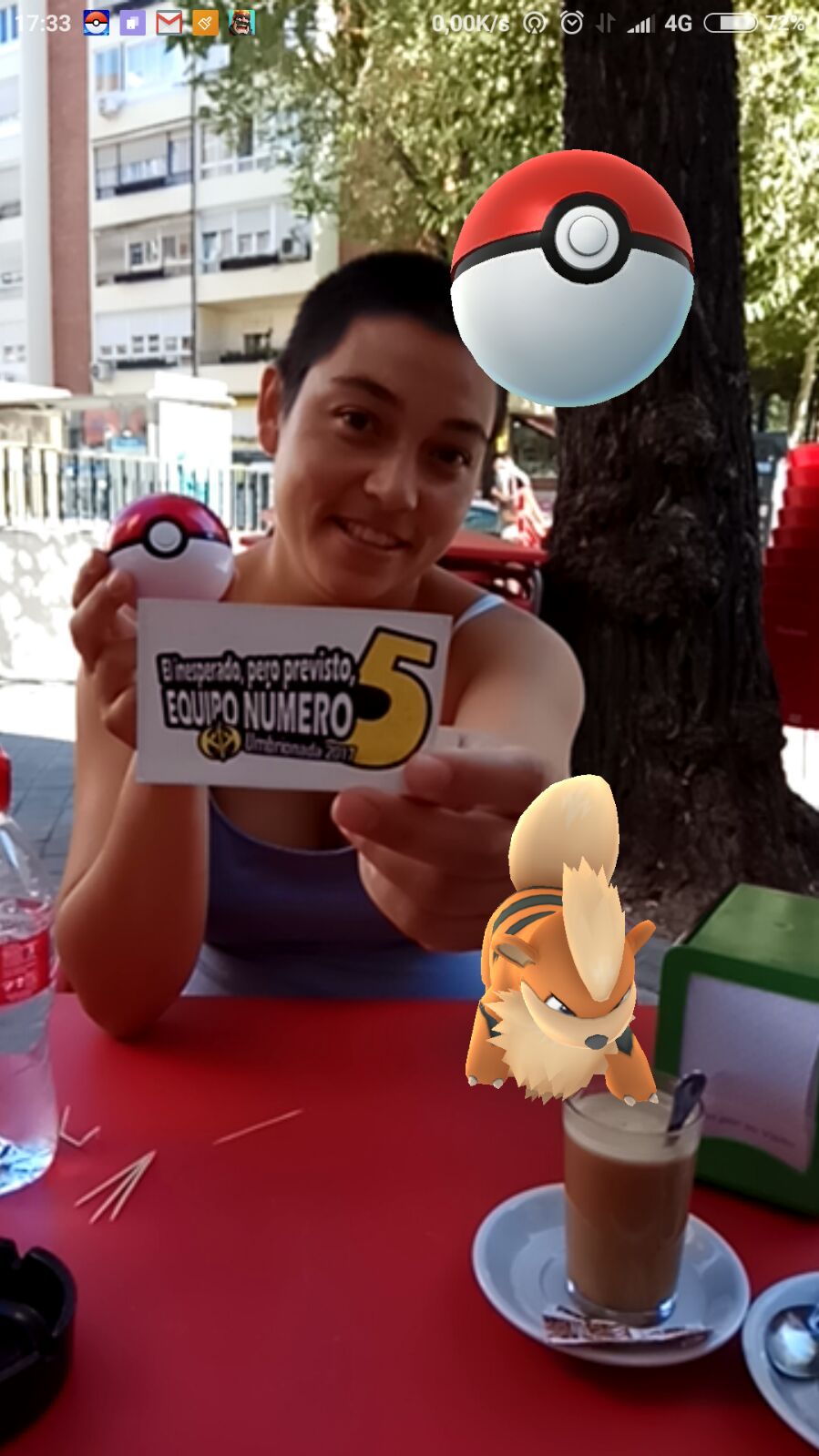 82. Sosteniendo una pokebola en la mano, con un pokemon de la app Pokemon Go cerca de ti.