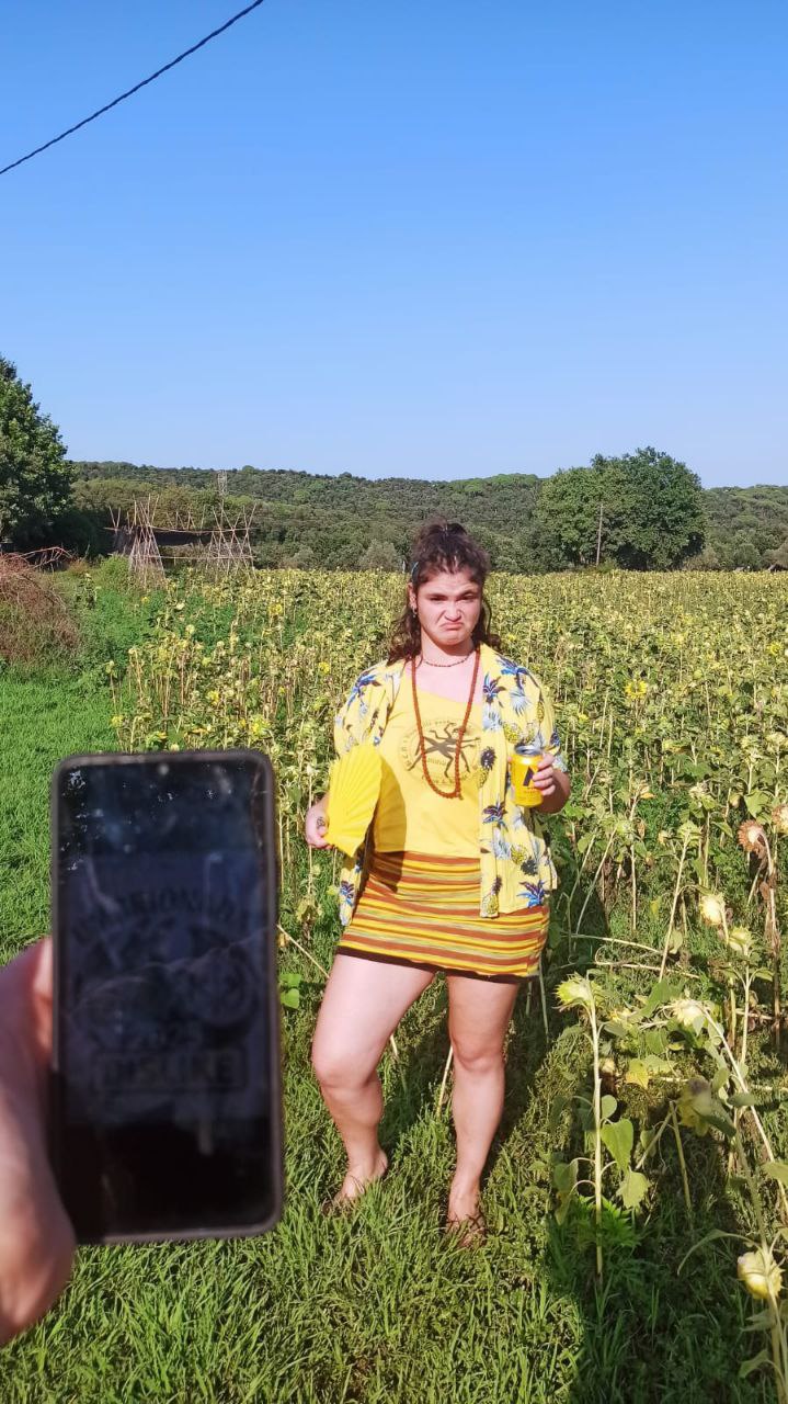 2. Vestido de amarillo y con cara enojada, al lado de un campo de girasoles que te dan la espalda.