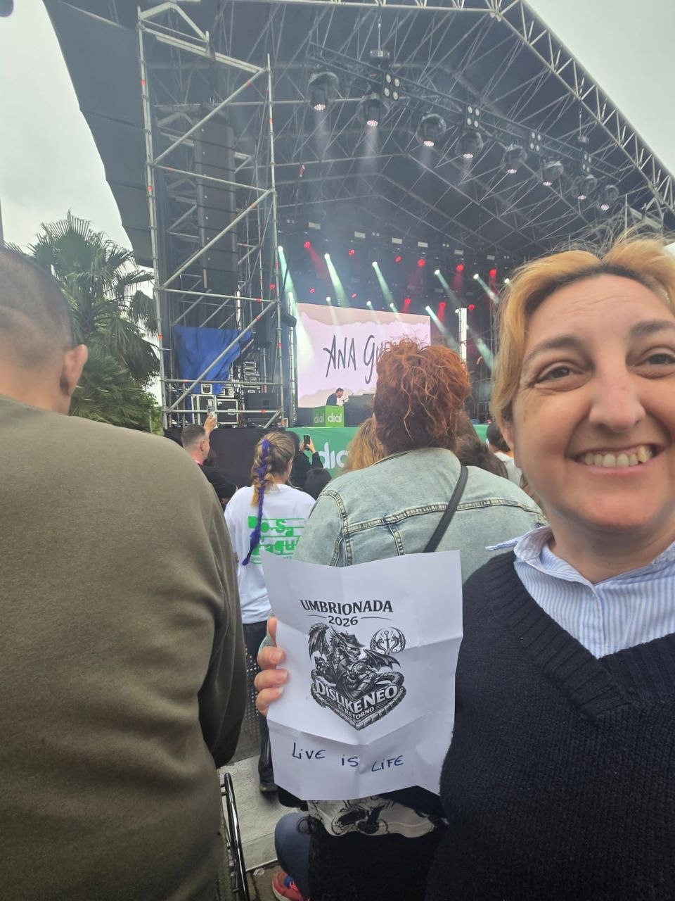 31.En un concierto, en medio de la multitud, con un cartel que diga 