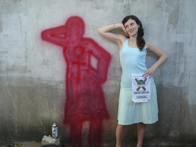 89. Una persona al lado de su propia silueta pintada en la pared. En la misma pose.