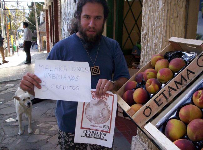 136.- En la calle vendiendo melocotones con un cartel que diga 