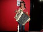 32. Con un acordeon entre las manos.