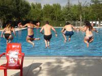 61. 	Cinco personas atrapadas en el aire mientras se tiran todos a la vez en una piscina.