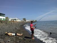 23. Con una caña de pescar, pescando una bota.