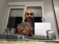 Foto 41.  Con un mazo de cartas de Magic y un cartel donde se pueda leer: “Del Magic también se sale”.