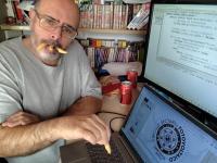 87 - Con un pico, frente a un ordenador que muestre algún código, como si se estuviese picando el teclado.