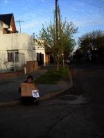 90. Con un cartel sentado en la calle que diga. 