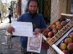 136.- En la calle vendiendo melocotones con un cartel que diga 