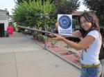 134.- Con un rifle o escopeta con una flor en el cañón. 